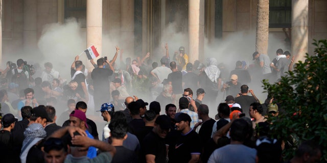 Iraqi security forces fire tear gas at supporters of Shiite cleric Muqtada al-Sadr inside the government palace, Baghdad, Iraq, Monday, Aug. 29, 2022.