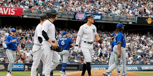 Aaron Judge of the New York Yankees walks to first base after he was hit by a pitch from Alek Manoah (6) of the Toronto Blue Jays during the fifth inning at Yankee Stadium on Aug. 21, 2022, in New York City.