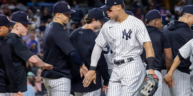 New York Yankees' Aaron Judge celebrates a win with teammate after a baseball game against the New York Mets, Monday, Aug. 22, 2022, in New York.