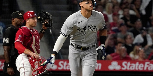 New York Yankees' Aaron Judge, right, drops his bat after hitting a three-run home run, next to Los Angeles Angels catcher Max Stassi and home plate umpire Alan Porter during the fourth inning of a baseball game Tuesday, Aug. 30, 2022, in Anaheim, California.