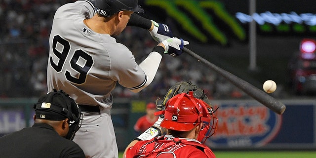 New York Yankees' Aaron Judge, center, hits a three-run home run as Los Angeles Angels catcher Max Stassi, right, watches along with home plate umpire Alan Porter during the fourth inning of a baseball game Tuesday, Aug. 30, 2022, in Anaheim, California. (AP Photo/Mark J. Terrill)