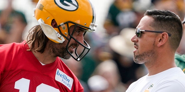 Green Bay Packers' Aaron Rodgers talks to head coach Matt LaFleur at the NFL football team's practice field Wednesday, July 27, 2022, in Green Bay, Wis. 
