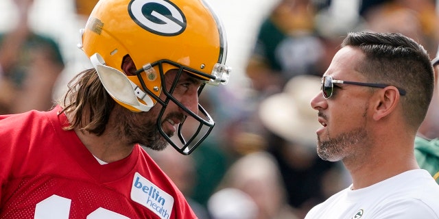 Green Bay Packers' Aaron Rodgers talks to head coach Matt LaFleur at the NFL football team's practice field Wednesday, July 27, 2022, in Green Bay, Wisconsin. 