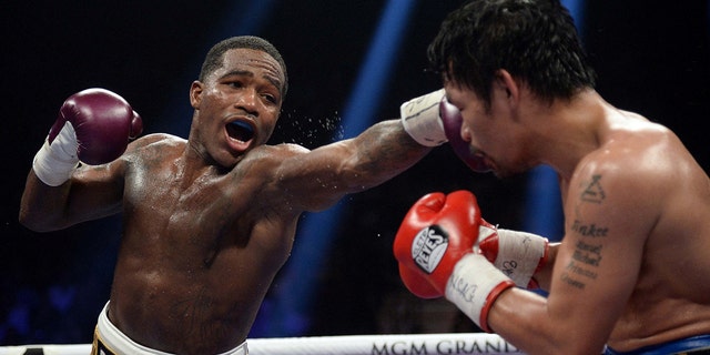 Manny Pacquiao (black trunks) and Adrien Broner (purple/gold trunks) box during a WBA welterweight world title boxing match at MGM Grand Garden Arena. Pacquiao won via unanimous decision.