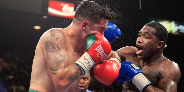 Carlos Molina (L) of the U.S. takes a punch from Adrien Broner, also of the U.S., during their super lightweight fight at the MGM Grand Garden Arena in Las Vegas, Nevada, May 3, 2014.