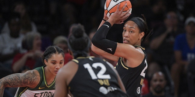 Las Vegas Aces forward A'ja Wilson, 권리, looks to pass to uard Chelsea Gray (12) to pass during the first half of a WNBA basketball game against the Seattle Storm, 일요일, 8월. 14, 2022, 라스 베이거스.