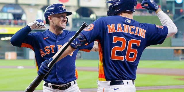 Houston Astros' Alex Bregman, left, and Trey Mancini, #26, celebrate after Bregman's two-run home run during the first inning of a baseball game against the Oakland Athletics, Sunday, Aug. 14, 2022, in Houston.