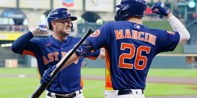 Houston Astros' Alex Bregman, left, and Trey Mancini, #26, celebrate after Bregman's two-run home run during the first inning of a baseball game against the Oakland Athletics, Sunday, Aug. 14, 2022, in Houston.