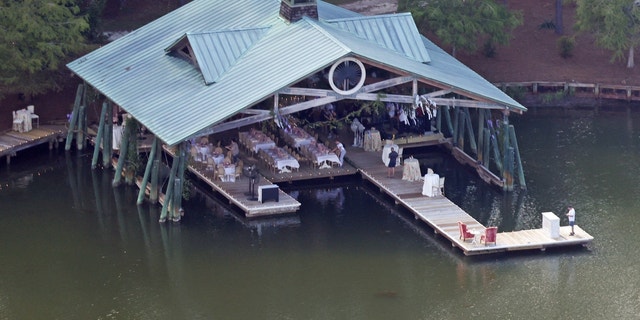 Tables and chairs are set up below a waterside gazebo. 