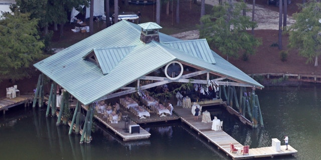Tables and chairs are set up below a waterside gazebo.