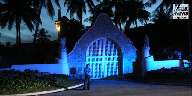Seorang penjaga berdiri di luar Mar-a-Lago di Palm Beach, Florida.
