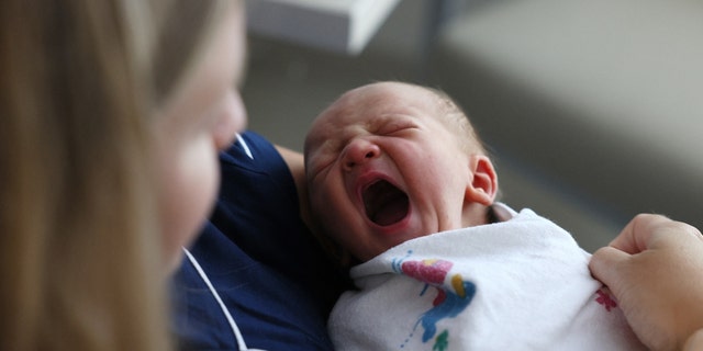 Concord, MA - July 28: A newborn baby boy yawns as he sits with his mother at Emerson Hospital. 