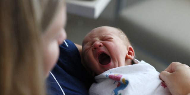 CONCORD, MA - JULY 28: Newborn baby boy sitting with his mother at Emerson Hospital yawns. 