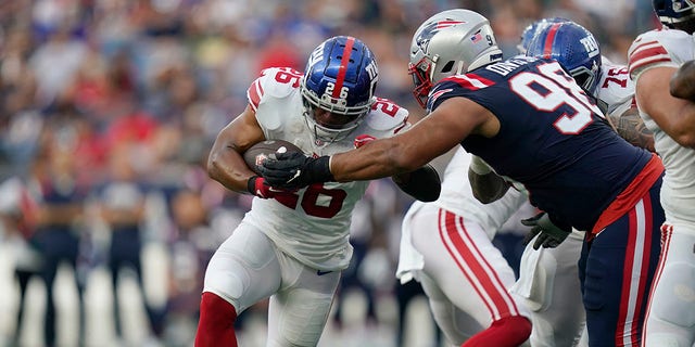 New York Giants running back Saquon Barkley (26) runs with the ball during the first half of a preseason game against the New England Patriots on Aug. 11, 2022, in Foxborough, Mass.