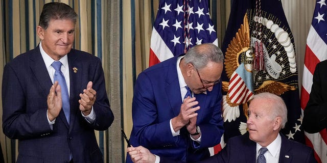 President Biden, right, moves to give Sen. Joe Manchin, D-W.Va., left, the pen he used to sign the Inflation Reduction Act with Senate Majority Leader Chuck Schumer, D-N.Y., at the White House on Aug. 16, 2022.