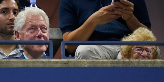 Former President Bill Clinton, left, and Ruth Westheimer watch play between Serena Williams, of the United States, and Danka Kovinic, of Montenegro, during the first round of the US Open tennis championships, Monday, Aug. 29, 2022, in New York.