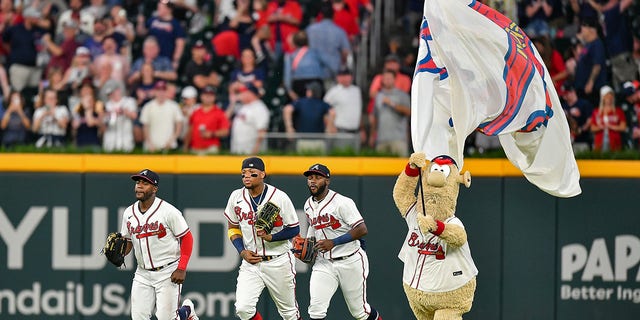 Atlanta's Guillermo Heredia, Michael Harris II, Ronald Acuna Jr. and mascot Blooper celebrate after the final out against the Oakland Athletics at Truist Park in Atlanta, Georgia, on June 7, 2022.