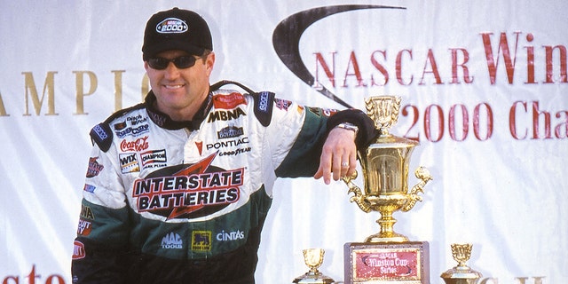 Bobby Labonte poses with the Winston Cup trophy after winning the title for Joe Gibbs Racing. Driving the Interstate Batteries Pontiac, Labonte won four Cup races on his way to the title.