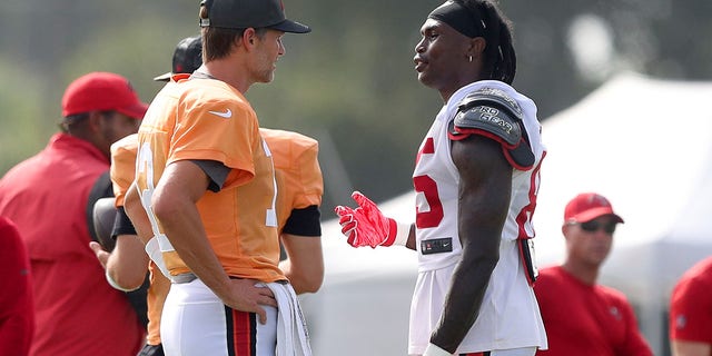 Tampa Bay Buccaneers quarterback Tom Brady (12) talks with wide receiver Julio Jones (85) during the Bucs and Miami Dolphins' joint practice Aug. 10, 2022, at the AdventHealth Training Center in Tampa, Fla.