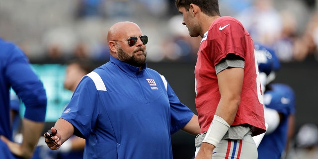 El mariscal de campo de los New York Giants, Daniel Jones, habla con el entrenador Brian Daboll durante la práctica del equipo de fútbol americano de la NFL en East Rutherford, NJ, el viernes 5 de agosto de 2022.