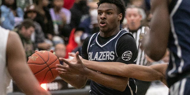 Sierra Canyons Bronny James (0) drives the ball under pressure of Corona Centennial boys basketball team in the Southern California Open Division regional basketball finals on Tuesday, March 8, 2022 in Corona, CA.