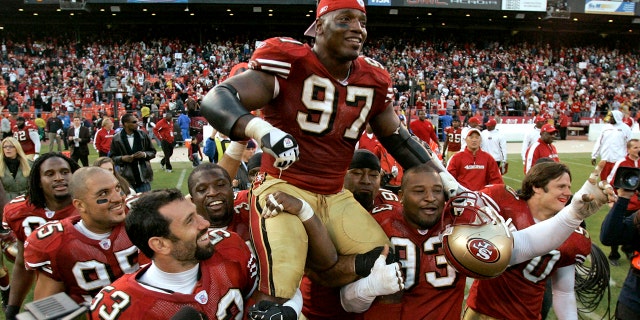 Forty-niners defensive end Bryant Young is carried off the field by teammates after their win over the Tampa Bay Buccaneers in San Francisco, on Dec. 23, 2007.