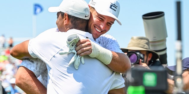 Tiger Woods hugs Bryson DeChambeau during practice for the PGA Championship at Southern Hills Country Club on May 18, 2022, in Tulsa, Oklahoma.