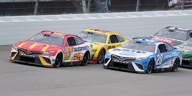 Bubba Wallace (23) races Joey Logano (yellow) and Christopher Bell (20) in the race at Michigan International Speedway in Brooklyn, Michigan, Aug. 7, 2022.