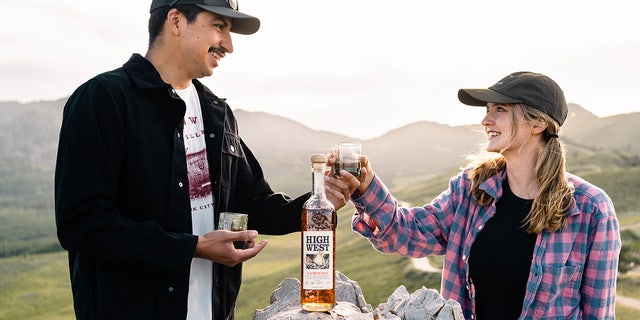 Two friends are shown with High West Distillery's seasonal Campfire whiskey.