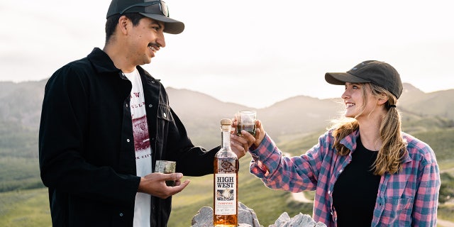 Two friends are shown with High West Distillery's seasonal Campfire whiskey.