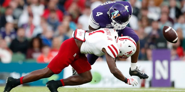 Northwestern running back Cam Porter (4) fumbles the ball as he is tackled by Nebraska defensive back Marques Buford (1) during the second half of an NCAA college football game, Saturday, Aug. 27, 2022, at Aviva Stadium in Dublin, Ireland.