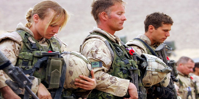 Canadian soldiers, joined by personnel from British, US, and Afghan forces, attend a Remembrance Day ceremony at Forward Operating Base Masum Gar.