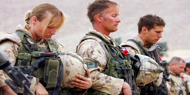 Canadian soldiers, joined by personnel from British, US, and Afghan forces, attend a Remembrance Day ceremony at Forward Operating Base Masum Gar.