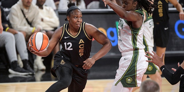 Las Vegas ace guard Chelsea Gray, 12, moves past Tina Charles of the Seattle Storm during the first half of a WNBA basketball game in Las Vegas on Sunday, August 14, 2022.