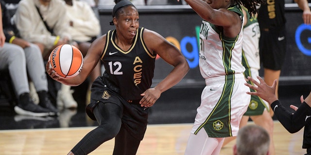 Las Vegas Aces guard Chelsea Gray (12) passes around Seattle Storm's Tina Charles during the first half of a WNBA basketball game Sunday, 8월. 14, 2022, 라스 베이거스.