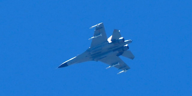 A fighter jet flies in the direction of Taiwan and is seen from the 68-nautical-mile scenic spot, the closest point in mainland China to the island of Taiwan, in Pingtan in southeastern China's Fujian Province, Friday, Aug. 5, 2022.