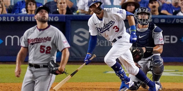 Los Angeles Dodgers' Chris Taylor, center, heads to first as he hits a solo home run while Minnesota Twins relief pitcher Michael Fulmer, left, watches along with catcher Gary Sanchez during the sixth inning of a baseball game Wednesday, Aug. 10, 2022, in Los Angeles.