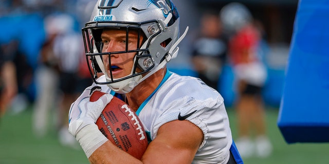 Carolina Panthers running back Christian McCaffrey carries the football during a drill at the team's Fan Fest in Charlotte, N.C., on Thursday, Aug. 11, 2022.