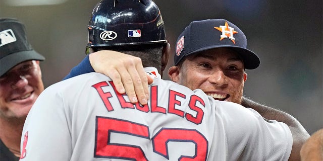Houston Astros' Christian Vazquez, right, hugs Boston Red Sox's Carlos Febles as they exchange lineups before a baseball game Tuesday, Aug. 2, 2022, in Houston.
