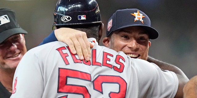Houston Astros' Christian Vazquez, right, hugs Boston Red Sox's Carlos Febles as they exchange lineups before a game on Tuesday, Aug. 2, 2022, in Houston.