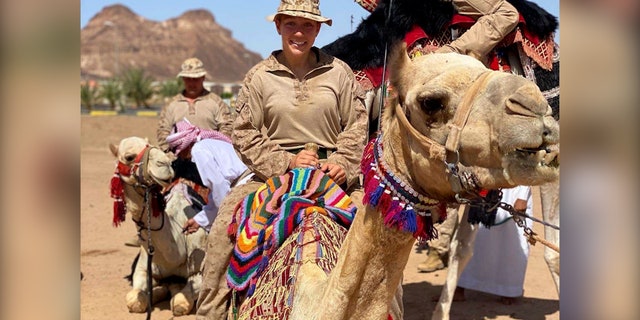Gee rides a camel in Saudi Arabia.