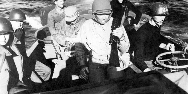 United States Coast Guard commander and former heavyweight boxing champ Jack Dempsey (1895-1983) and his crewmates are shown in a landing craft as they head for the beach, Okinawa, Japan, April 13, 1945.
