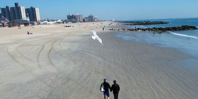 A couple walks on the beach on March 9, 2016 in Coney Island, New York. 