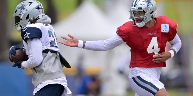 Quarterback Dak Prescott #4 of the Dallas Cowboys hands off to running back Ezekiel Elliott #21 during training camp drills at River Ridge Fields on August 1, 2022 in Oxnard, California.