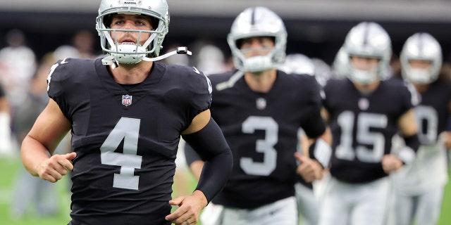 Quarterbacks Derek Carr, #4, Jarrett Stidham, #3, and Chase Garbers, #15 of the Las Vegas Raiders, warm up before a preseason game against the New England Patriots at Allegiant Stadium on August 26, 2022 in Las Vegas.