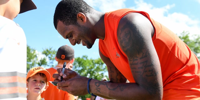 Deshaun Watson #4 of the Cleveland Browns signs autographs after Cleveland Browns training camp at CrossCountry Mortgage Campus on July 30, 2022 in Berea, Ohio.