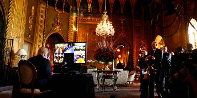 Then-President Donald Trump listens during a Christmas Eve video teleconference with members of the military at his Mar-a-Lago estate in Palm Beach, Florida, on Dec. 24, 2019.