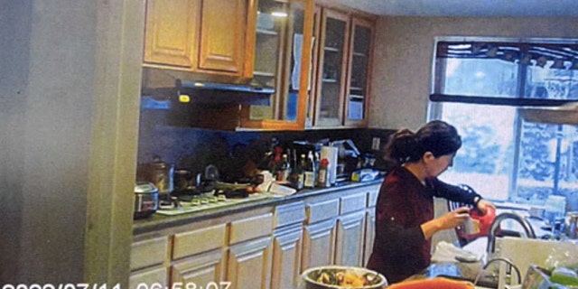 Yu is seen in a screengrab from video opening a bottle of Drano in the kitchen.