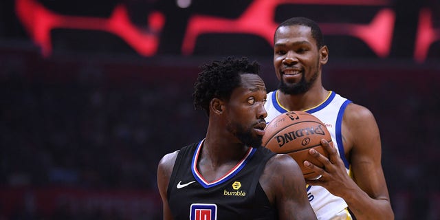 Patrick Beverley, #21 of the LA Clippers, looks back at a smiling Kevin Durant, #35 of the Golden State Warriors, during Game Two of Round One of the 2019 NBA Playoffs at Staples Center on April 18, 2019 in Los Angeles.  