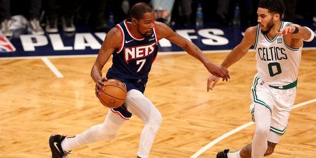 Kevin Durant, #7 of the Brooklyn Nets, drives as Andre Drummond, #0 of the Brooklyn Nets, defends during Game Four of the Eastern Conference First Round Playoffs at Barclays Center on April 25, 2022 in the Brooklyn borough of New York City.